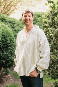 Smiling man, standing with hands in pockets,surrounded by greenery, wearing 204 Missouri River Boatman's Shirt