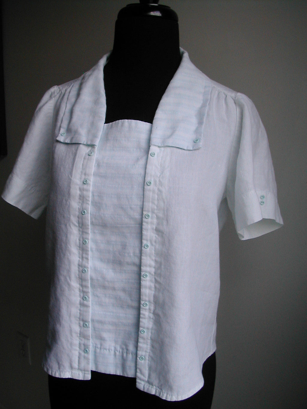 A mannequin wearing 210 Armistice Blouse with rectangle collar.