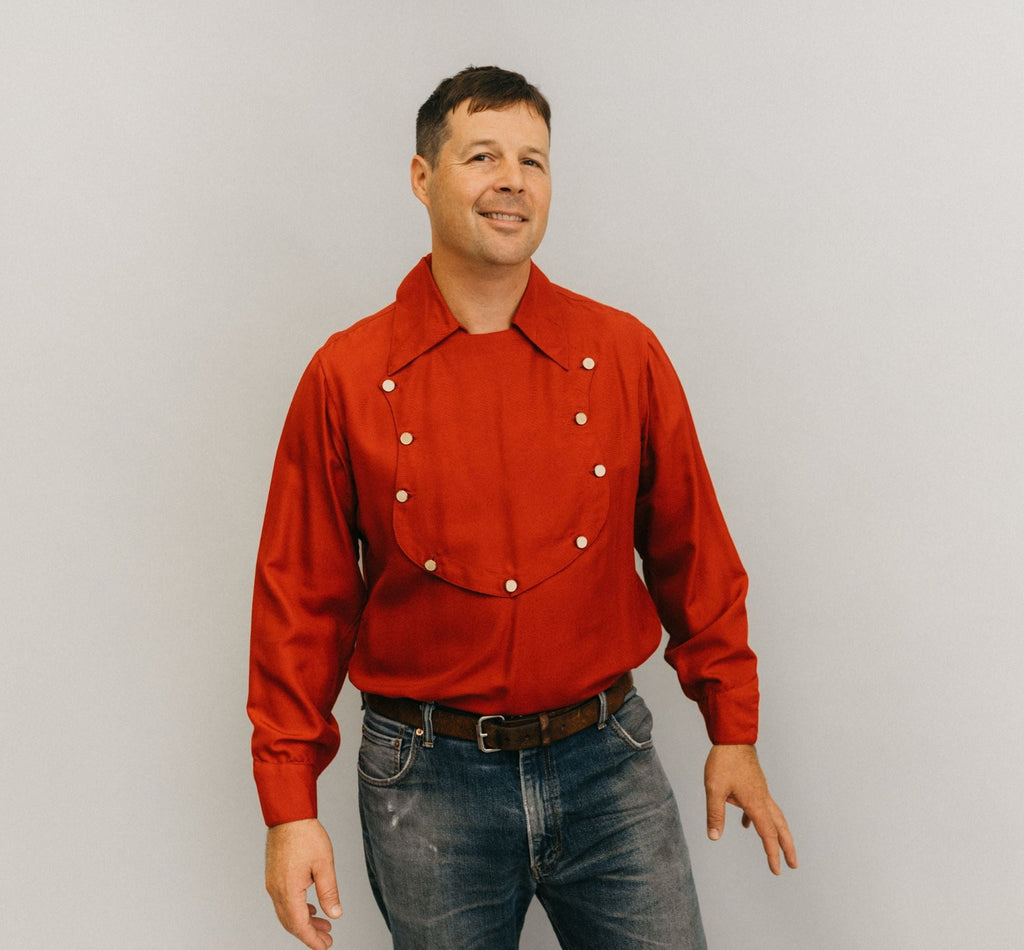 Man standing in front of a white studio backdrop wearing 212 Five Frontier Shirts View C with a buttoned bib shape in the front.