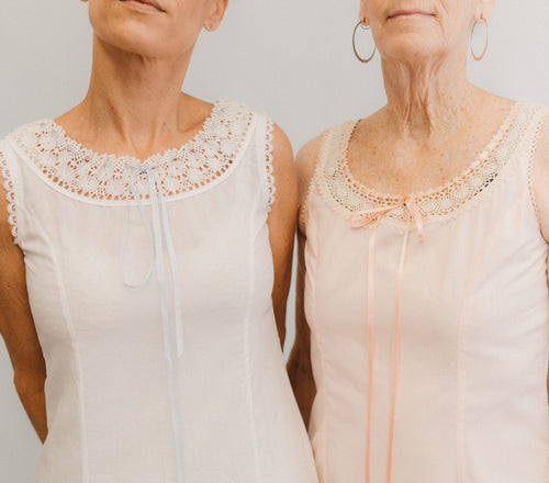 Close up of the top of two slips with lace at the necklines.