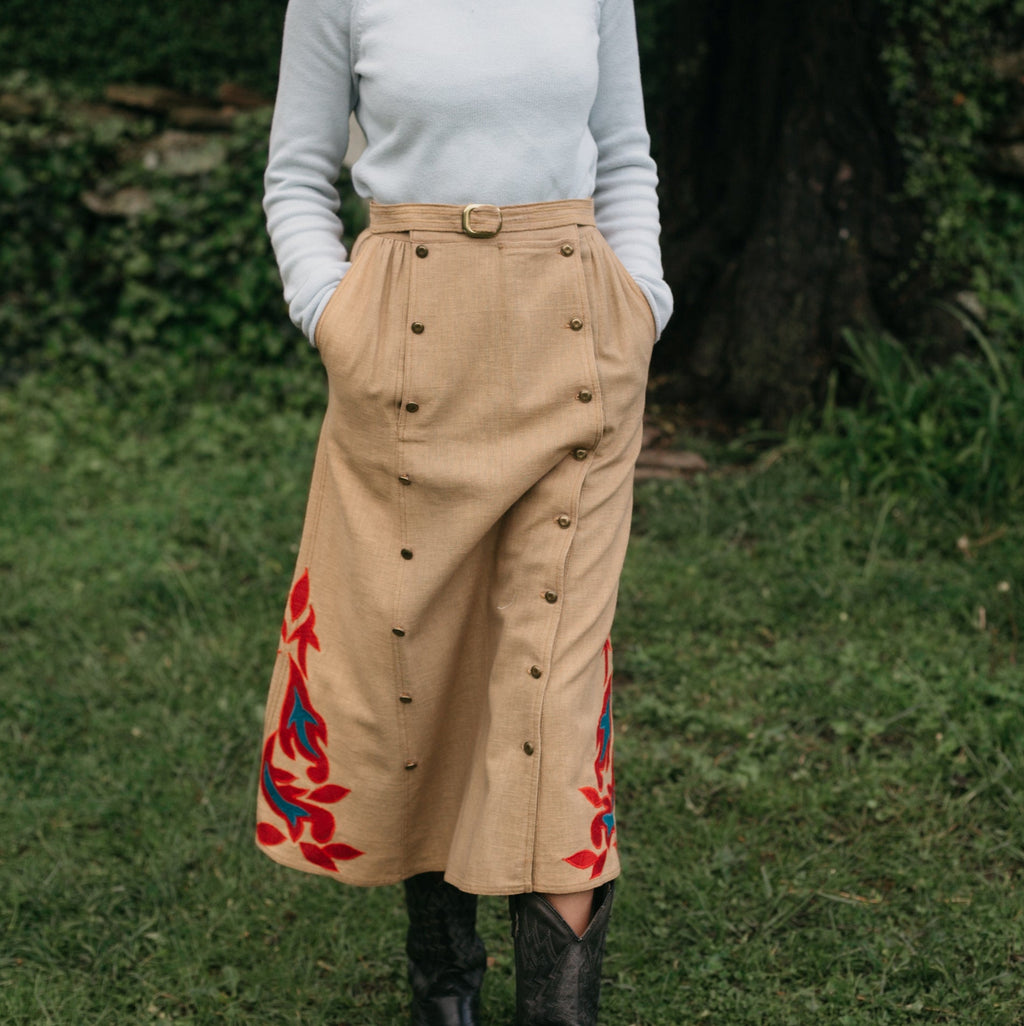 Close up of woman walking surrounded by greenery 231 Big Sky Riding Skirt buttoned to the left for a skirt effect