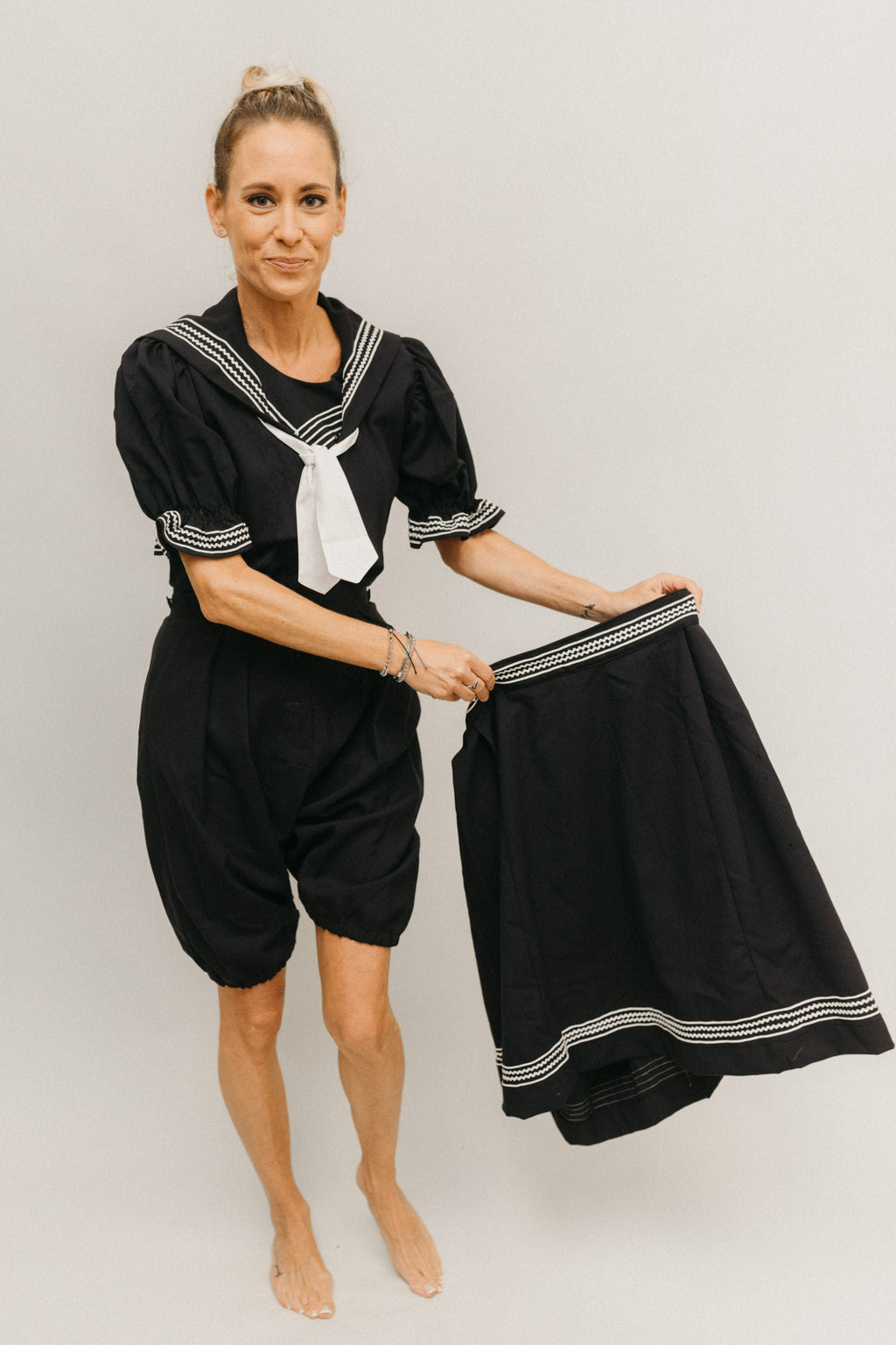 White blonde woman wearing 253 Vintage Bating costume romper and while holding the skirt to the side.