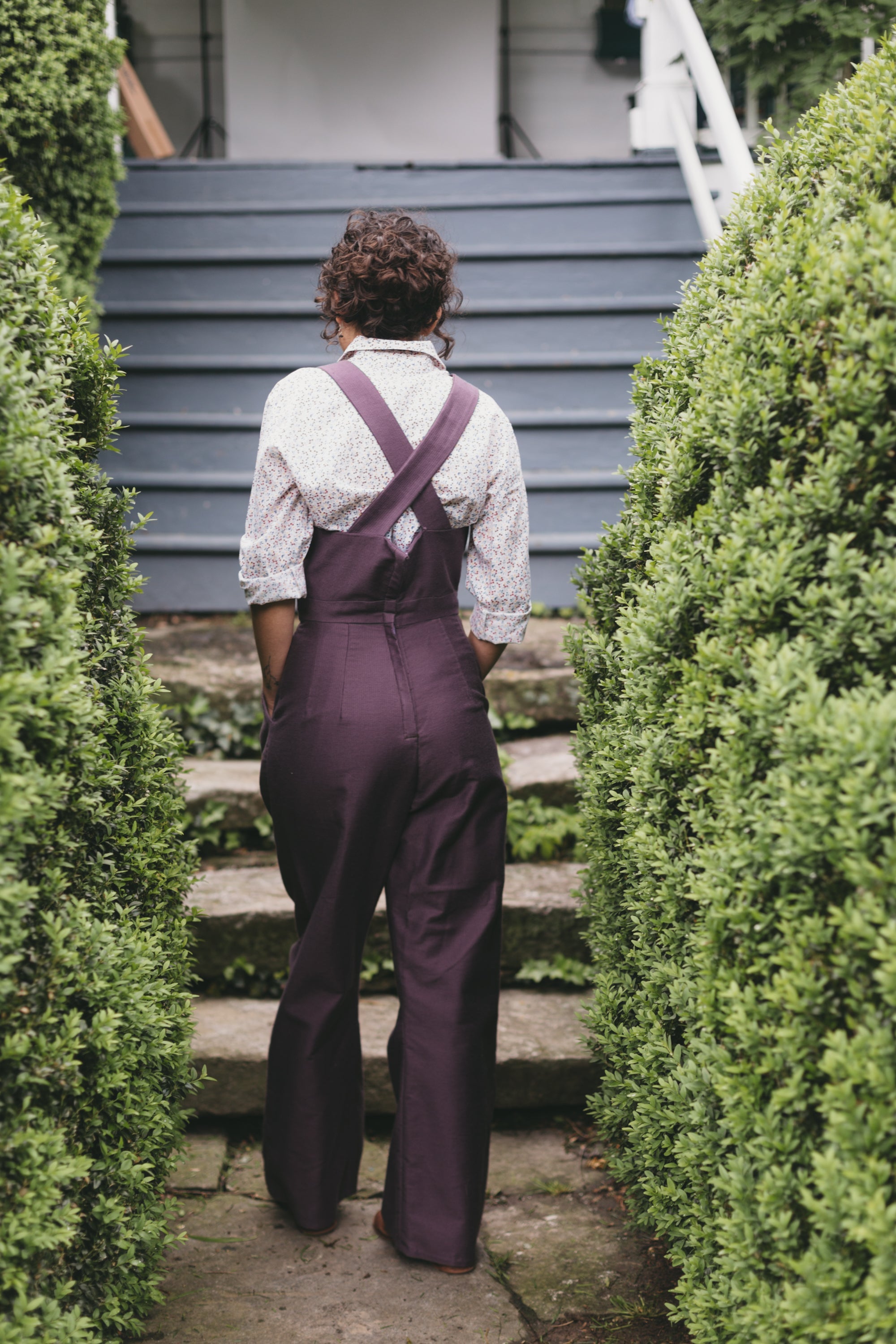 Back view of young woman walking wearing the 240 Rosie the Riveter Overalls.