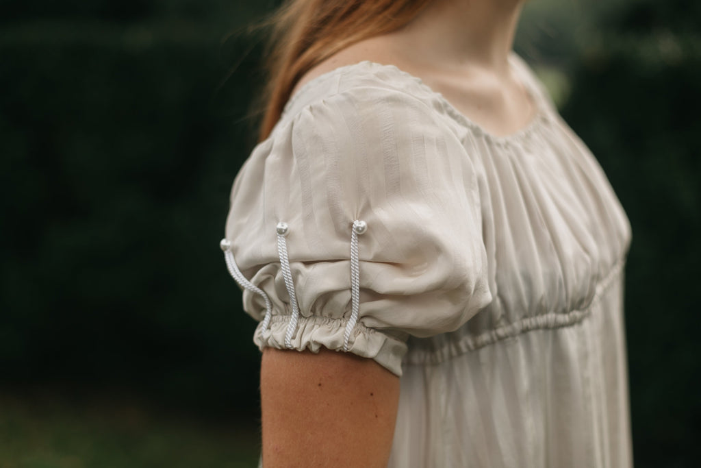 Close up of the sleeve of 215 Empire Dress with short puffed sleeves with cord detailing.