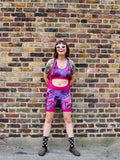Rouleur Leggings view B - image of woman in brightly coloured bib shorts standing against a brick wall